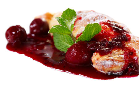 Cherry strudel close-up with cherry sauce, sugar and mint. Isolated on whiteの写真素材