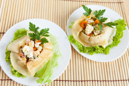 Two Salad with boiled vegetables wrapped in a pancake on bamboo matの写真素材