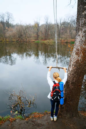 Woman hiker with bungee in the hands near autumn river. Active Lifestyleの写真素材