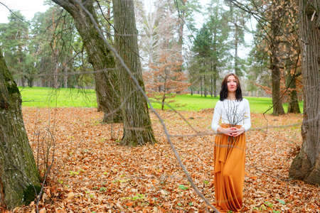 Autumn young woman outdoors with dry twigs in her hand. Natural conceptの写真素材