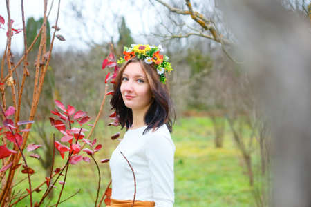 Brunette young girl with flower wreath in the autumn park. Beauty conceptの写真素材