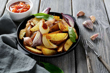 Rustic baked potatoes in a pan. Wooden backgroundの写真素材