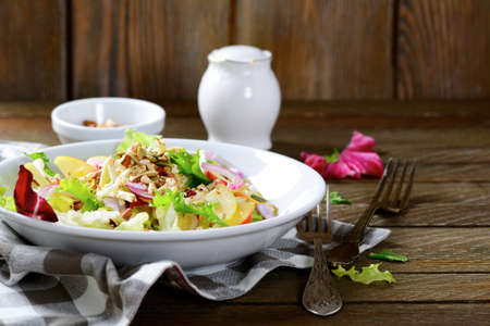 Salad of fruit and walnuts on a white plate, vegetarian foodの写真素材