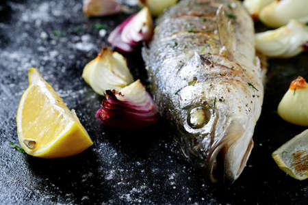 Roasted sea bass on a dark sheet, seafoodの写真素材