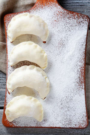 Uncooked dumplings on the cutting board. Homemade food