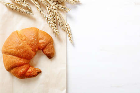 Tasty French croissants with ears of wheat. Top view