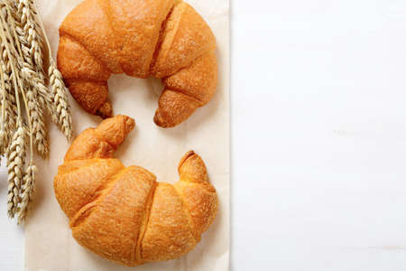 Delicious French croissants with spikelets of wheat. Top viewの写真素材