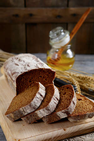Bread sliced into pieces and honey on the cutting board. Food close-up
