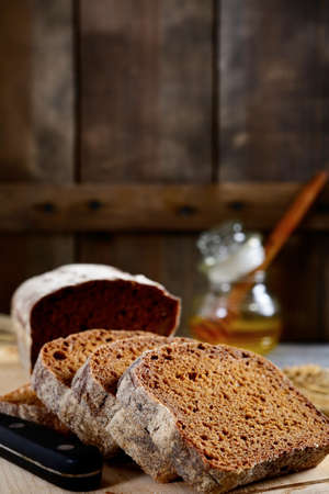 Slices of rye bread and honey on a wooden background. Food close-up