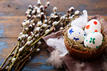 Painted Easter eggs in a nest and pussy willow branch. Spring holiday