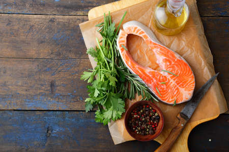 Raw Steak Salmon, parsley, rosemary and spice on a cutting board. Top viewの写真素材