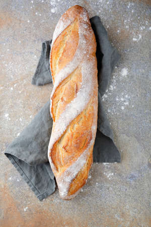 Crunchy Baguette on the napkin on slate. Top view