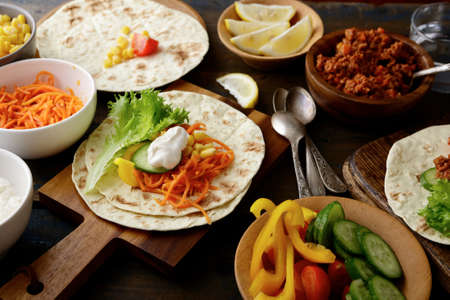 Mexican Tacos with different ingredients on wooden backgroundの写真素材