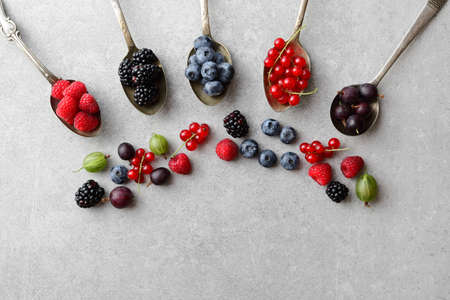 Mixed berries in old spoons on slate backgroundの写真素材