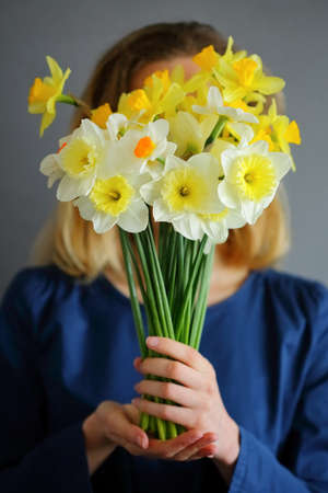Beautiful bouquet narcissus in the hands of girl. Spring flowersの写真素材