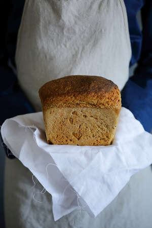 Fresh Bread on a napkin in the hands of a woman baker