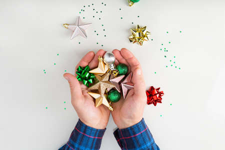 Overhead view of holiday present in hands. Christmas decorations red and green color