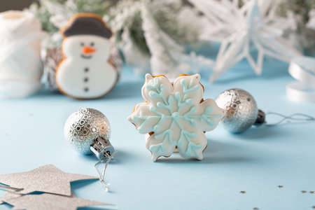Christmas gingerbread cookies with silver Christmas decorations on blue surfaceの写真素材