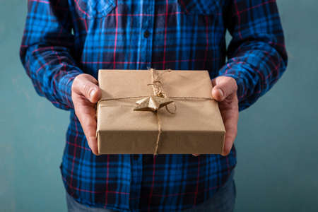 Christmas gift in hands on white surface, flat layの写真素材