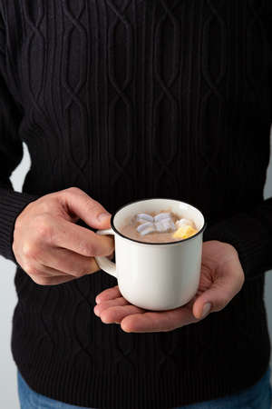 Christmas gift in hands on white surface, flat layの写真素材