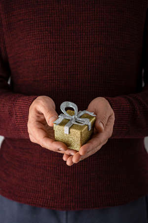 Christmas gift in hands on white surface, flat layの写真素材