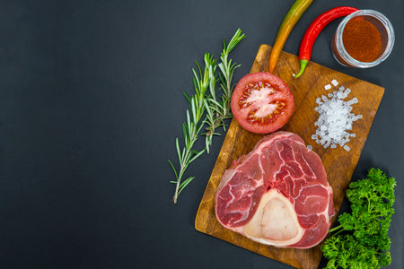 Fresh raw beef steaks ready for grilling, shot from above. Seasonings, vegetables, fruits and herbs.の写真素材