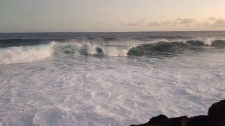 Waves breaking on the rocks at sunset in Oahu, Hawaii.
