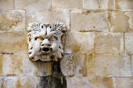 Sculpted stone mask figure on ancient fountain on the side of Church of Saint Blaise  St Vlaha  Dubrovnik, Croatiaの写真素材