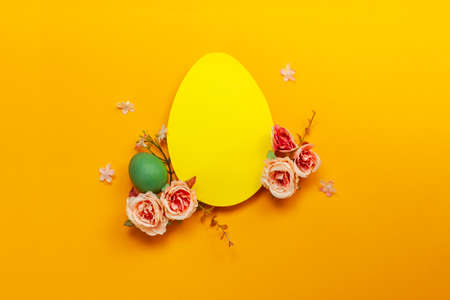 Easter holiday concept with  handmade  yellow egg, flowers on yellow background. Flat lay concept,...