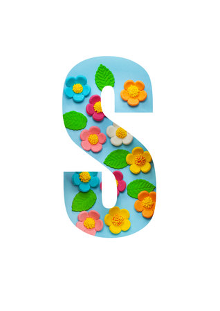 The letters  S of the English alphabet is cut out of flowers on a blue  background.Floral pattern, texture for stores,sales,websites,postcards and holiday greetings.の写真素材