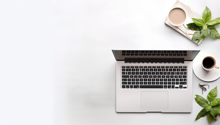 Laptop computer with coffee cup and plant on white background, top viewの素材