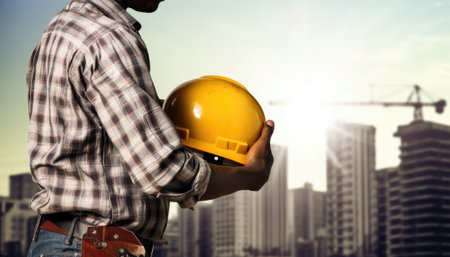 engineer or architect with yellow safety helmet on construction site background.の素材