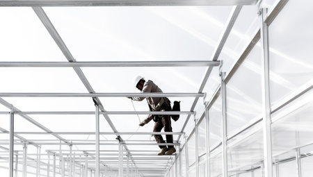 Low angle view of young man in helmet and goggles working on construction siteの素材