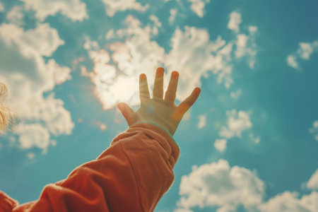Reaching for the sky, Hand outstretched towards clouds, hope and freedomの素材