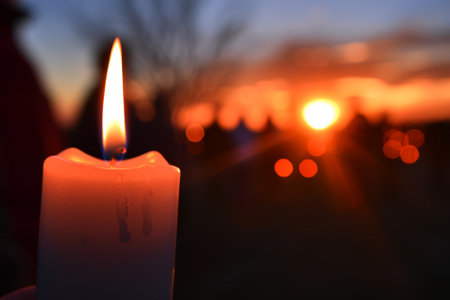 Burning candle in a cemetery at sunsetの素材