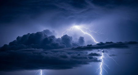 Powerful lightning bolts illuminate dark, heavy storm clouds during a severe thunderstorm, showcasing a dramatic and intense weather event.の素材