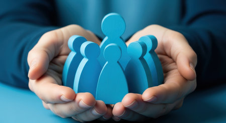 Hands gently cradling a group of stylized light blue human figures, symbolizing community, protection, and support for social well being.の素材