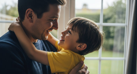 Happy father embracing his young son, both smiling and looking at each other with affection. captures a moment of family bonding and love.の素材