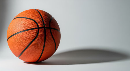 Classic orange basketball with its iconic pebbled texture and black lines, resting on a clean studio surface. symbolizes sport, game, competition, and athletic activity. ideal for themes of fitness, recreation, and professional play.の素材