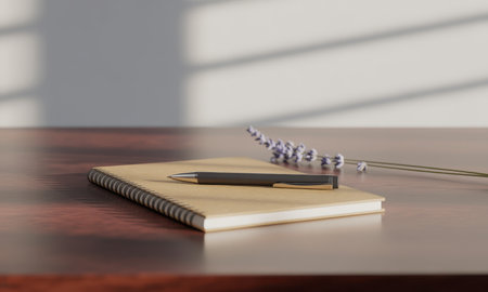Beige spiral notebook with a black ballpoint pen and a sprig of lavender on a wooden table, illuminated by natural light and window shadows.の素材