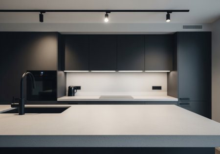 Modern kitchen interior featuring dark matte cabinets, light grey countertop, black sink, and track lighting. contemporary minimalist design for home decor.の素材