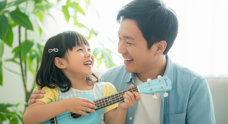 Japanese father and young daughter happily playing a blue ukulele together at home, sharing a joyful and heartwarming moment. family bonding through music and laughter.の素材