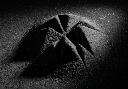 Dark granular powder sculpted into an abstract mound with sharp angular peaks and valleys. textured surface with subtle highlights and shadows, creating a mysterious and elegant visual.の素材