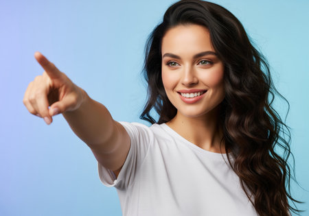 Close up portrait of a beautiful young woman with long dark hair and a bright smile, pointing her index finger to indicate selection or direction.の素材