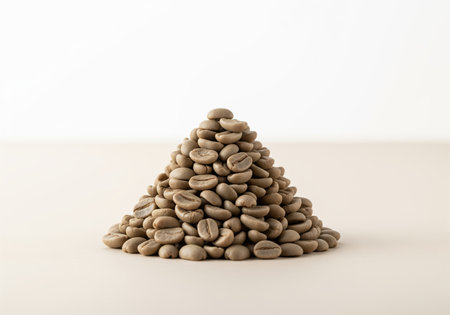 Conical pile of raw, unroasted green coffee beans displayed in a clean studio setting. essential ingredient for brewing and roasting processes, symbolizing freshness and quality.の素材