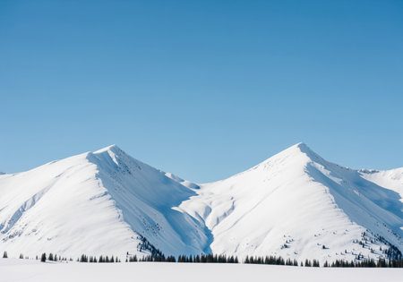 Snow capped mountain peaks dominating a vast winter landscape under a bright, cloudless azure sky. wilderness, cold climate, high altitude, and natural beauty concept.の素材