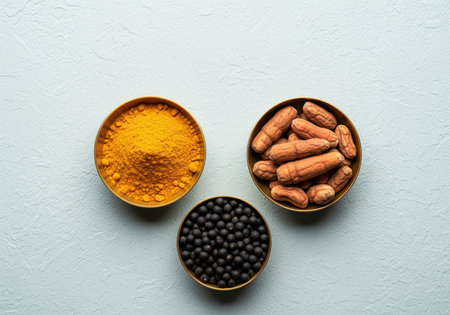 Turmeric powder, dried roots, and black ayurvedic medicine pills displayed in three bowls on a textured light surface. focus on natural health and traditional indian medicine.の素材