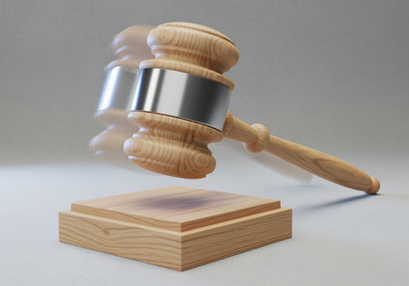 Wooden judge gavel with a metallic band shown mid swing, about to strike the sound block. represents authority, final decision, law, justice, and auction conclusion.の素材