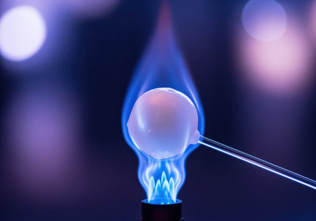 Close up of a chemical experiment where a glowing sphere is held over an intense blue flame, illustrating combustion and heat transfer.の素材