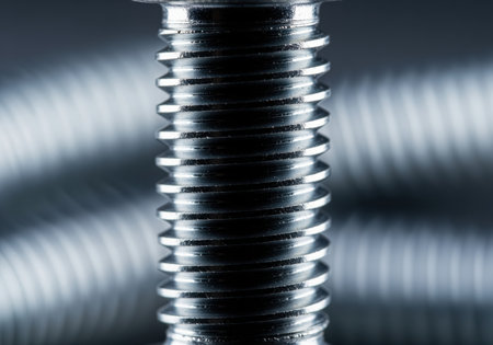 A detailed macro shot captures the precise, helical structure of a shiny metallic bolt thread, emphasizing industrial design and mechanical precision.の素材